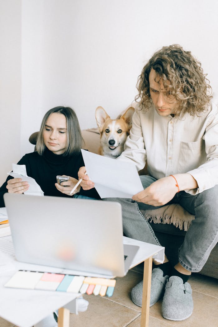 who-we-are A couple working on a laptop with their dog relaxing nearby, highlighting modern work-life balance.